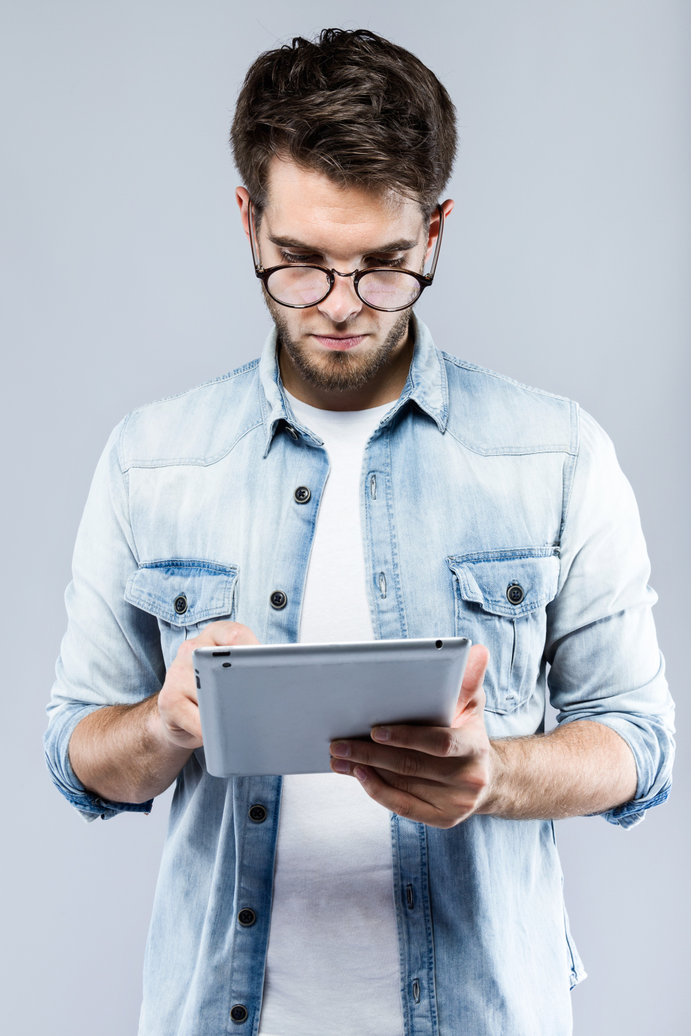 handsome-young-man-using-his-digital-tablet-gray-background